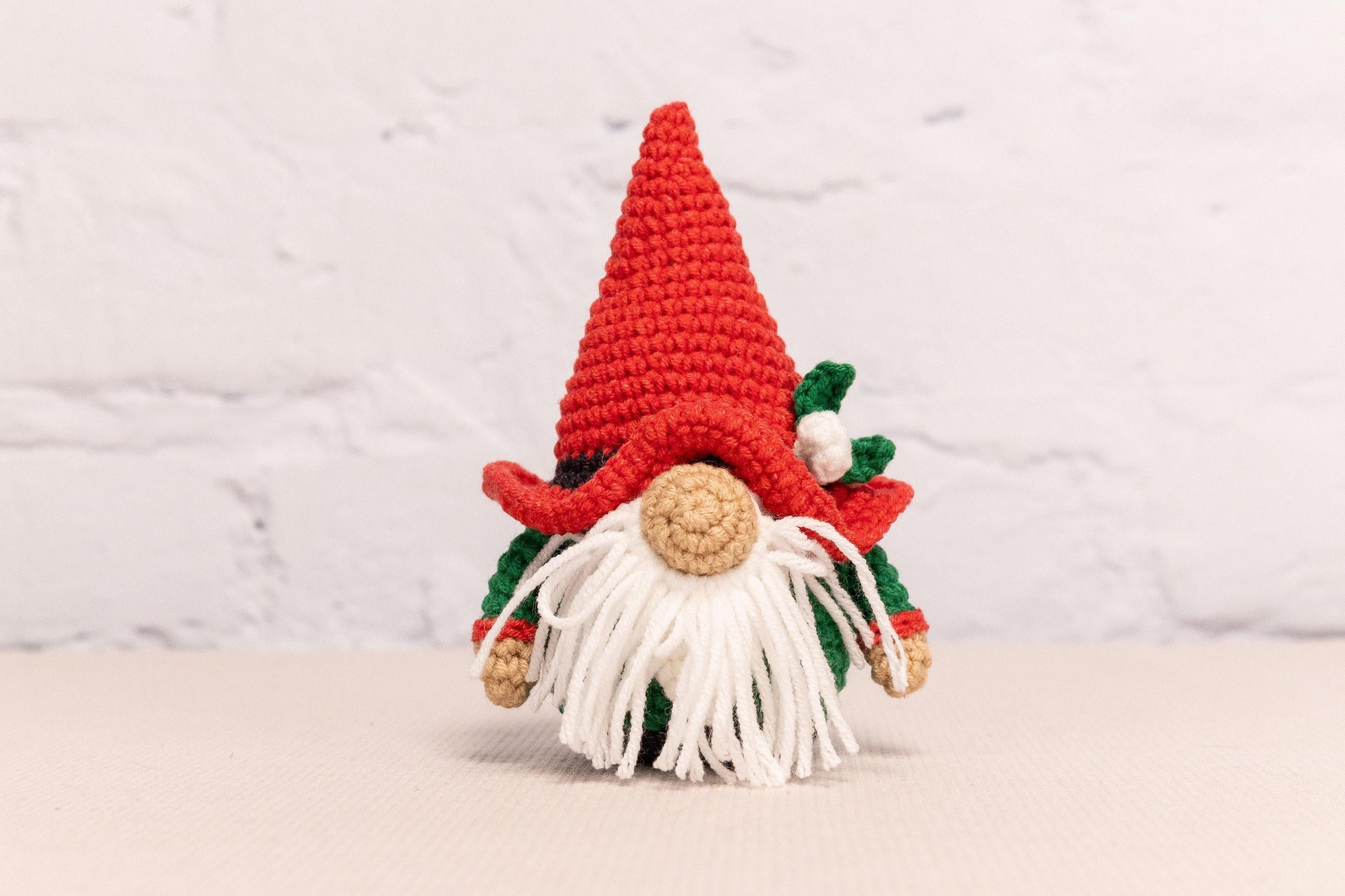 a crocheted gnome with a red hat and white beard